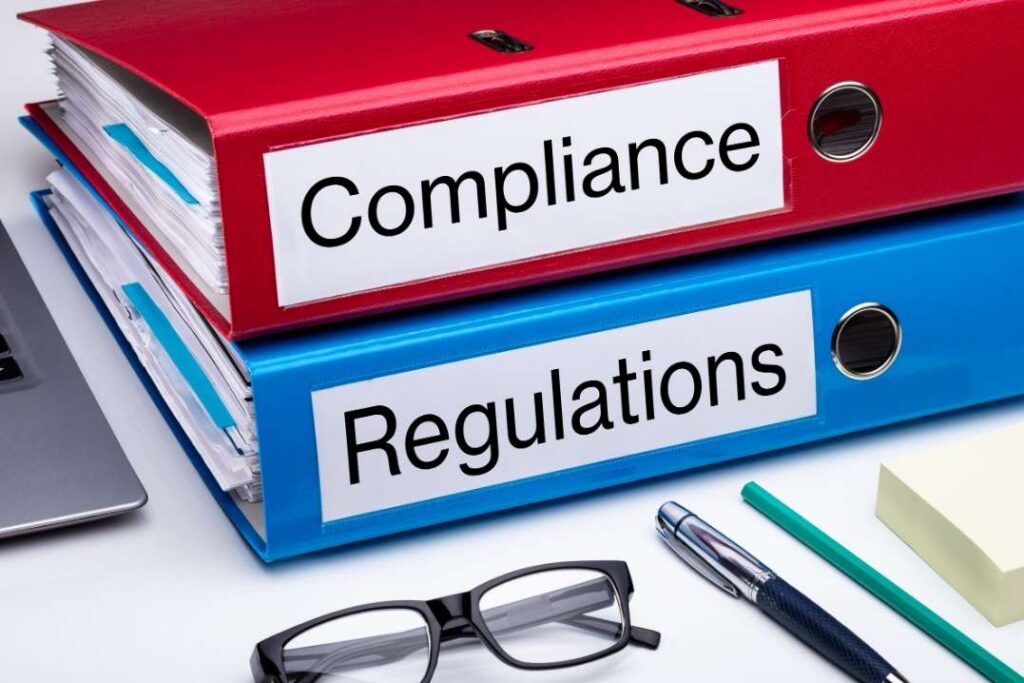 Tranche 2 compliance and regulations binders on an office desk.